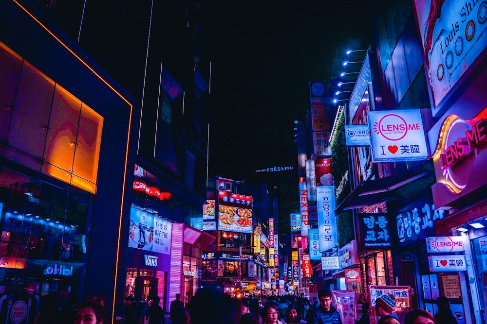 A crowded street full of neon signs at night