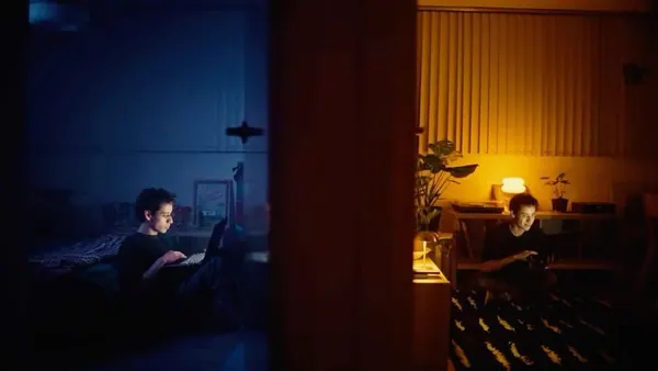 Two people on their screens in separate rooms at night