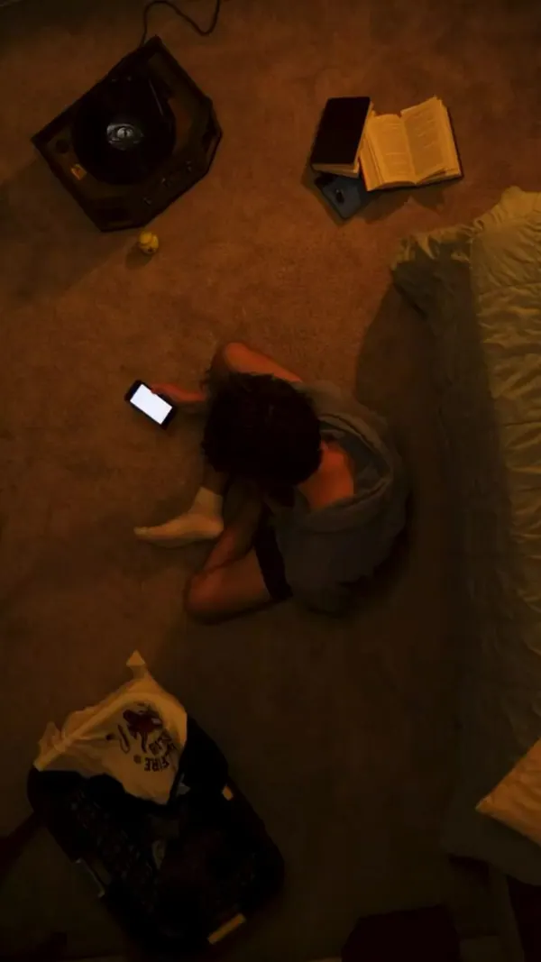 Overhead shot of a woman lying on the floor beside her phone