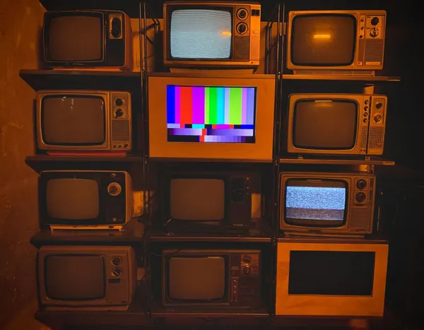 A wall of stacked vintage television sets